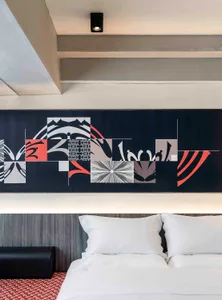 Modern bedroom design featuring a geometric textile print pattern on the headboard wall.