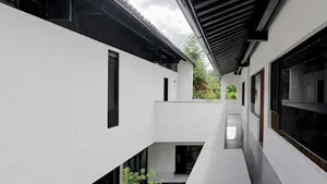 A modern house with concrete walls and a black roof.