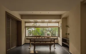 A modern living room with a wooden table and seating area.