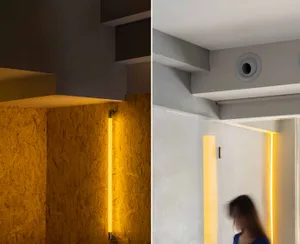 現代極簡設計，展示一盞流線型壁燈，搭配金屬框架，安裝於拋光混凝土牆面上。