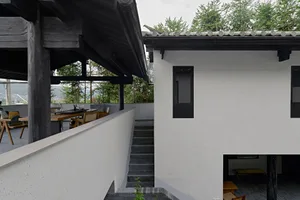 A modern residential exterior featuring concrete and stone materials.