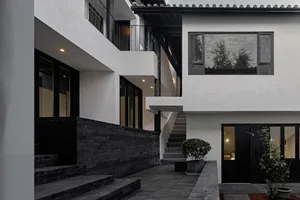 Modern residential facade featuring black wood and concrete.
