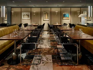 A modern restaurant interior featuring marble flooring and contemporary furniture.