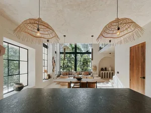 A spacious living room with natural fiber pendant lights and large windows.
