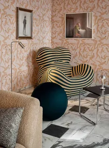 A modern living room featuring a striped armchair and a round ottoman on a checkered floor.