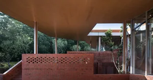 Modern building exterior with brick walls and large glass windows.
