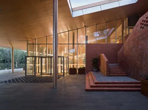 Modern architectural entrance featuring glass, brick, and concrete materials