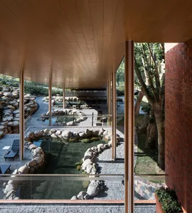 A modern landscape with concrete paths and a pond.