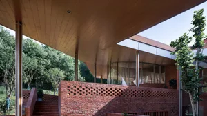 Outdoor view of a modern public library with red brick walls and concrete elements.