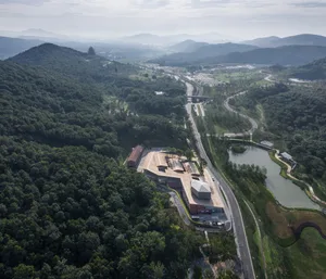Aerial view of a mountain valley with architectural structures and roads.