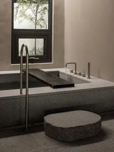 Modern minimalist bathroom with concrete bathtub, wood accents, and industrial style fixtures.