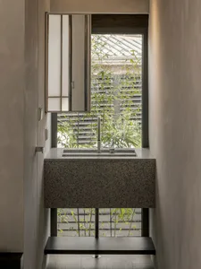 Minimalist bathroom featuring a granite sink and a view of a serene garden.