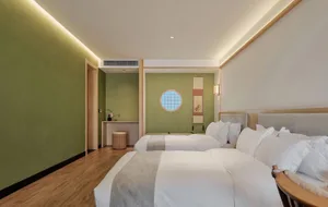 Well-lit bedroom with minimalist decor featuring wooden floors and beige textiles.