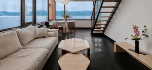 A minimalist living room with a white sofa, hexagonal coffee tables, and natural stone accents.