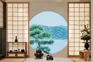 Modern residential interior with a Zen theme, featuring wooden walls and furniture, a round window overlooking a serene lands