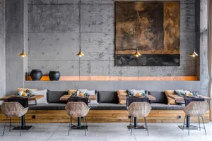 Industrial-themed restaurant interior with concrete walls and seating.
