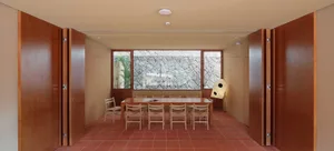 Conference room with minimalist design featuring wood and stone materials.
