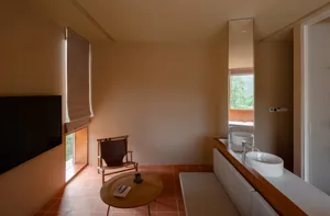 A modern contemporary living room featuring a sleek coffee table with books and a small cup, a comfortable lounge chair with