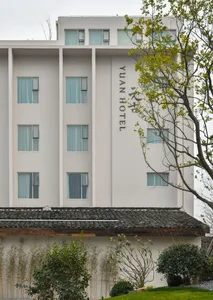 Modern hotel building with a white facade and grey concrete roof.
