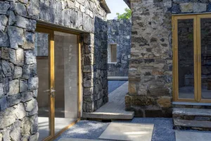 Modern house entrance with stucco walls and glass doors.