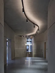 Concrete corridor with modern lighting fixtures and a sleek, minimalist design.