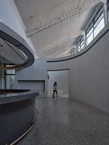 Modern minimalist lobby with concrete walls and curved reception desk