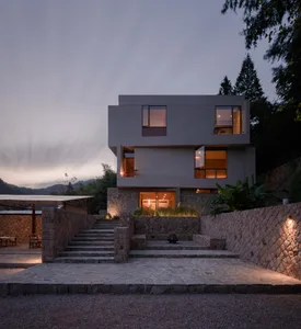 A modern residential home with concrete, stone, and glass materials.