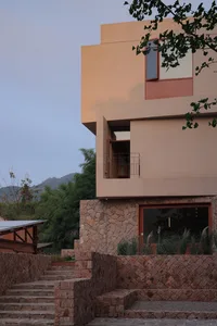 Modern residential architecture featuring concrete and glass on a hillside.