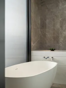 A minimalist modern bathroom featuring marble flooring and fixtures.
