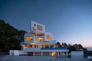 Modern house with white concrete exterior during twilight.