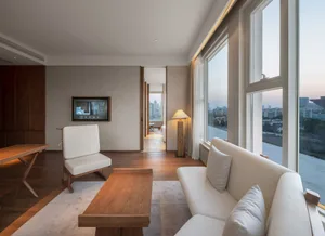A modern living room featuring a white sofa, wooden coffee table, and minimalist design.
