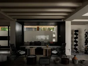 Living room with industrial design featuring dark wood furniture and concrete floor.