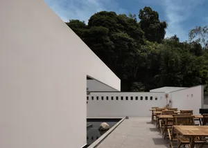 Minimalist architectural outdoor space with concrete walls and a stone water feature.