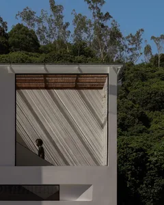 A modern building exterior featuring metal cladding, with trees in the background.