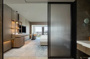 A modern hotel suite featuring marble and glass materials.