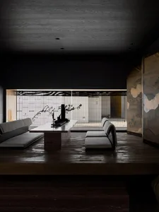 Minimalist living room with wood flooring, white furniture, and large windows.
