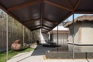 Outdoor space with modern minimalist design features comprising concrete, stone, and wooden elements.