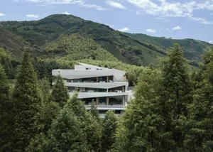 A modern, residential building with glass and concrete exterior materials.