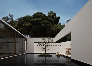 Modern residential space featuring glass, wood, and concrete materials.