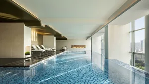Modern design swimming pool with blue mosaic tiles on the floor.