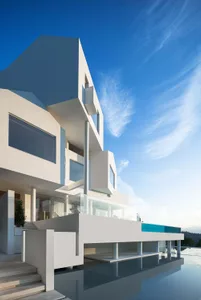 Modern residential building with large glass windows, concrete structure, and steel accents.