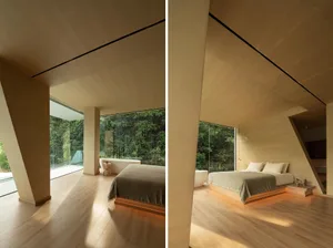 Modern bedroom featuring a wooden platform bed with a backdrop of a forest and large glass windows.