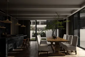 A modern dining room featuring a long wooden table with marble accents.