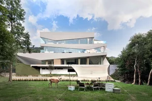 A modern residential building with glass and concrete architectural features.