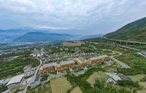 Aerial view of a mountain town with modern buildings and natural surroundings.