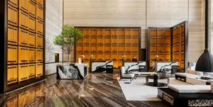 A modern hotel lobby featuring marble and concrete finishes.