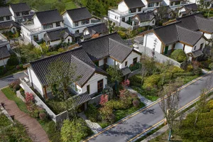 Residential front yard with white stone walkway, terracotta tiles on roof, and concrete curbs.