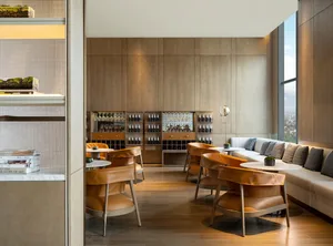現代餐廳酒吧，搭配木質地板、皮革座椅與金屬層架。