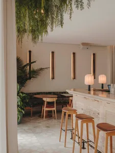 A modern cafe bar featuring concrete walls, wooden furniture, and stone accents.