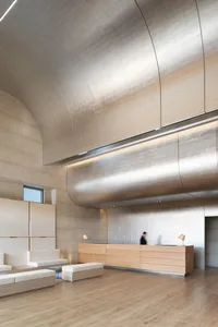 A contemporary lobby featuring a metallic ceiling and minimalist design.